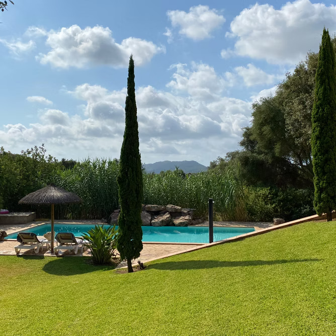 Pool mit Schilf, Zypressen und Bergblick