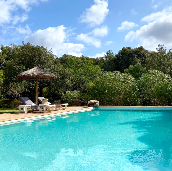 Pool mit Strohschirm und Liegen